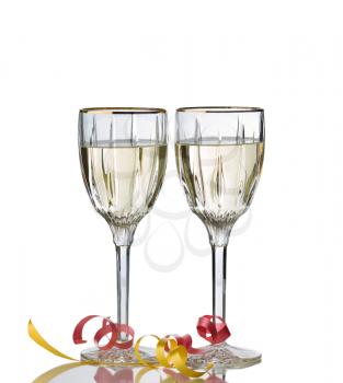 Elegant drinking glasses filled with white wine isolated over white background with reflection and party ribbons