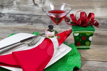 Dinner setting for Christmas Holiday with gift on Rustic Wood