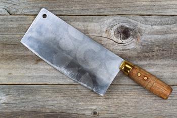 Close up of a large old traditional butcher knife on rustic wood 

