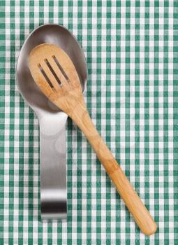 Traditional wooden spoon in stainless steel spoon rest on striped cloth napkin. Format in vertical layout. 