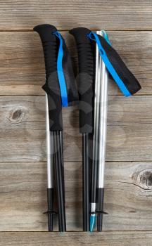 Brand new walking poles for hiking on rustic wooden boards. Layout in vertical format.