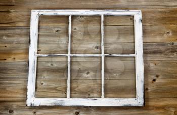 Vintage window, fading white paint, on rustic cedar wooden boards. 