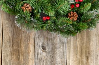 Christmas border with decorative wreath on rustic wooden boards. 