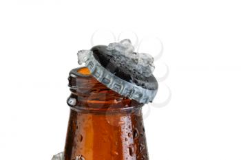 Close up view of a beer bottle neck, with cap off, covered with ice and condensation. Layout in horizontal format isolated on white. Focus on bottle cap with shallow depth of field.