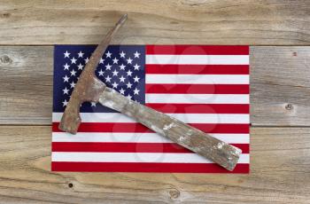Old hammer and a United States of America flag on rustic wood. Labor concept for USA. 