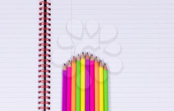 Colorful staggering pencils, tips facing upward, on a clean spiral notebook. Copy space available. 