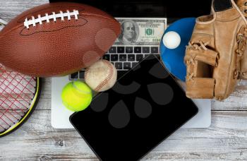Overhead view of sports equipment with computer technology and money for betting concept 