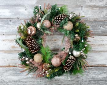 Illuminated Christmas holiday wreath on rustic white wood 