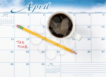 Tax due date marked on calendar with work supplies and fresh coffee 
