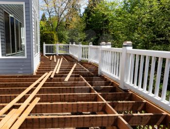 Outdoor wooden cedar deck being remodeled with all floor boards removed  