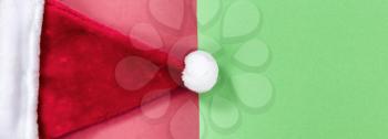 Red and green background with Santa Claus cap for Christmas season 