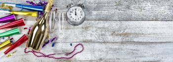 Clock nears midnight for happy New Year concept with golden champagne, drinking glasses and party decorations 