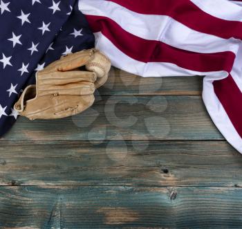 United States flag with American baseball and mitt on faded blue wooden planks for sport concept 