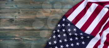 Waving American flag on right side of faded blue wooden planks for happy memorial or Independence Day background concept 
