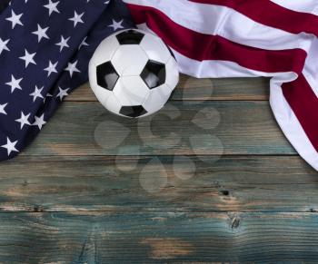 United States flag with soccer ball on faded blue wooden planks for sport concept 