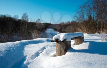 Bench covered with snow in the rural