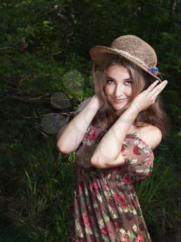 Beautiful girl in the national dress and hat stand in the  forest
