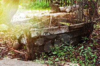 Last place of old broken boat in autumn garden.