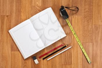 Blank notepad with office supplies on wooden table. Above view.