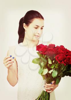 Young beautiful girl in white dress with bouquet of red roses and business card in hand isolated on white background.