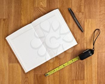 Blank notepad with office supplies on wooden table. Above view.