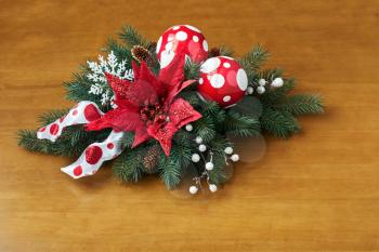 Composition from Poinsettia Plant with spruce branches on wooden background. Closeup.