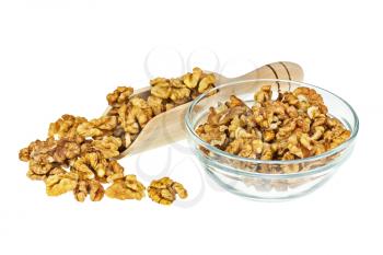 Handful of walnuts in scoop and glass bowl isolated on white background. Closeup. Selective focus.