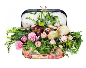Colorful floral arrangement of roses and lilies in acardboard chest isolated on white background.