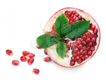 Pomegranate fruit with green leaves isolated on white background.