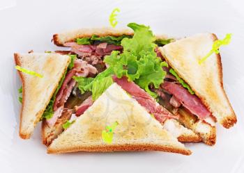 Sandwiches with  chicken, bacon and vegetables isolated on white plate. Closeup.