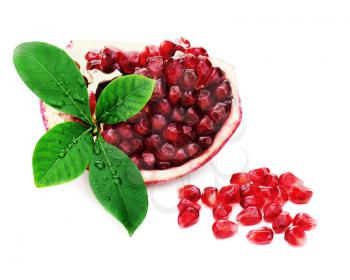 Part of pomegranate fruit with green leaves isolated on white background.
