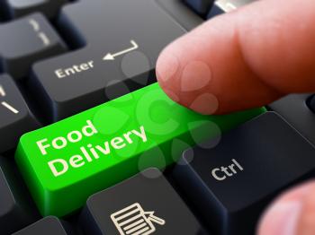 Food Delivery - Written on Green Keyboard Key. Male Hand Presses Button on Black PC Keyboard. Closeup View. Blurred Background.
