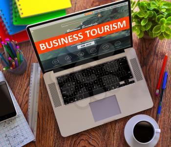 Business Tourism Concept. Modern Laptop and Different Office Supply on Wooden Desktop background.