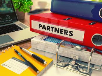 Red Office Folder with Inscription Partners on Office Desktop with Office Supplies and Modern Laptop. Business Concept on Blurred Background. Toned Image.