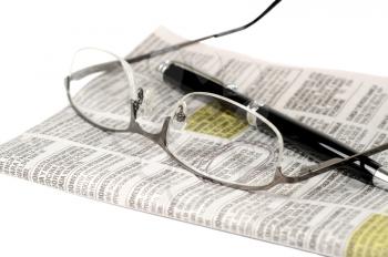 Glasses and pen over a newspaper classifieds page