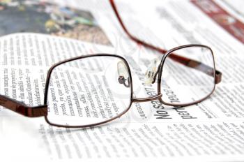 Macro shot of reading glasses on a newspaper