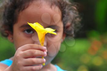 Small girl offering a yellow flower