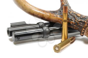 Macro shot of a rifle and deer antler with bullets