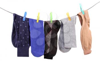 Several socks hanging from a clothes line isolated on white