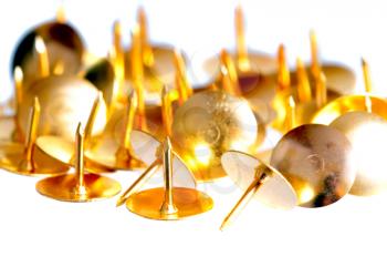 Several golden pin tacks isolated on white