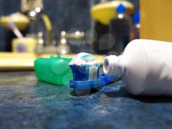 Toothbrush and paste with shallow depth of field in a bathroom top
