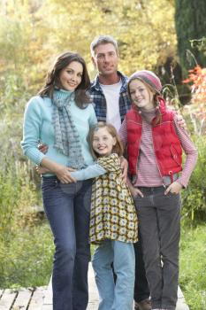 Family Group Standing Outdoors On Wooden Walkway In Autumn Landscape