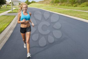 A beautiful fit and healthy blond woman road running while listening to music on her portable mp3 player