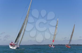 A group of 3 yachts sailing on a summer's day.