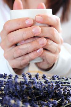 Hands of a woman holding a cup