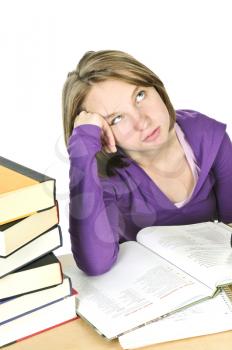 Unhappy teenage girl studying at the desk