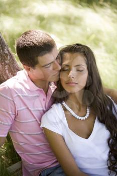 Image of tender man kissing girls face while spending time together