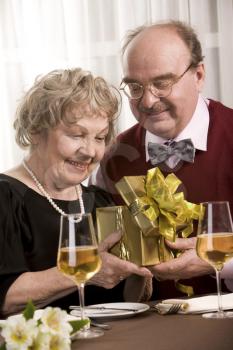 Image of happy seniors sitting at table during family celebration