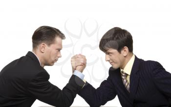 Two businessmen looking at each other seriously while doing arm wrestling
