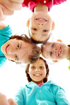 Company of four joyful children looking at camera 